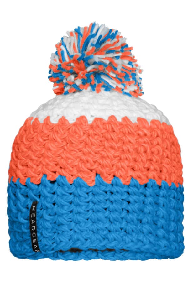 A crocheted cap featuring a pompon, with vibrant orange, white, and blue colours, and a branding logo.