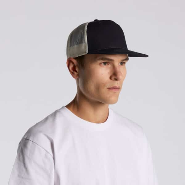 A black and beige trucker cap with a mesh back, displayed on a model wearing a white T-shirt.