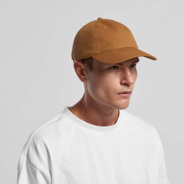 A man wearing a brown Access Canvas Cap, paired with a plain white t-shirt, against a neutral background.