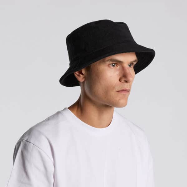 A black Terry bucket hat featured on a model wearing a white t-shirt. The hat has a logo on it.