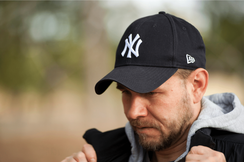 Logo design tips for caps | a man wearing a hat with a logo