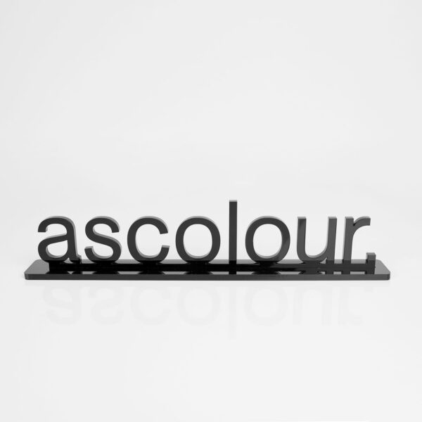A black promotional product featuring the word "ascolour" in bold lettering on a sleek base.