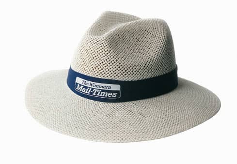 A wide-brimmed straw hat in light beige with a navy blue band featuring a logo.