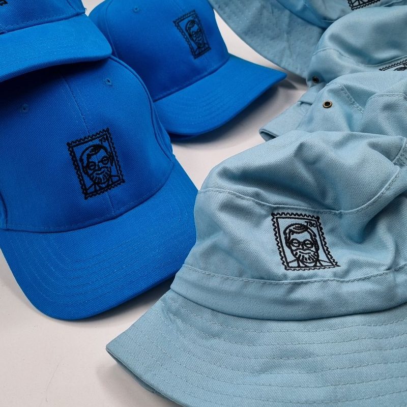Matching embroidered logo on blue caps and light blue bucket hats
